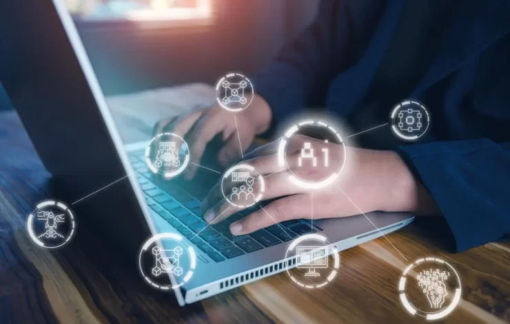 Eine Person, die an einem Laptop mit angezeigten KI-Symbolen arbeitet.