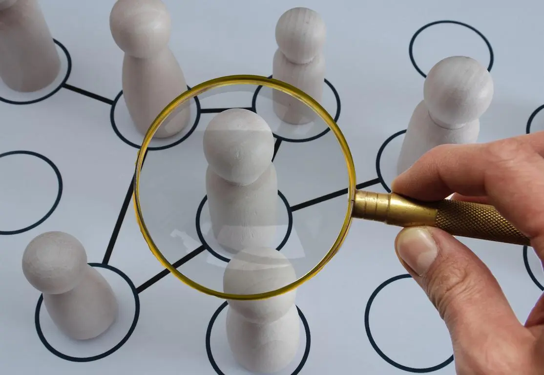 Eine Person, die einer Gruppe von Menschen das Wertversprechen einer Lupe demonstriert.