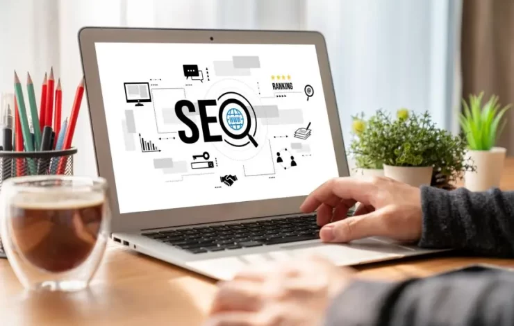 Ein Mann benutzt einen Laptop mit SEO darauf.