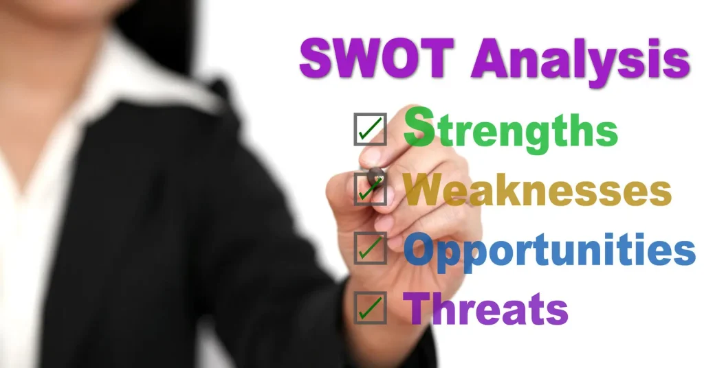 Eine Person im Anzug schreibt mit einem Marker den Text „SWOT-Analyse“ und eine Checkliste mit Stärken, Schwächen, Chancen und Risiken auf eine transparente Oberfläche.