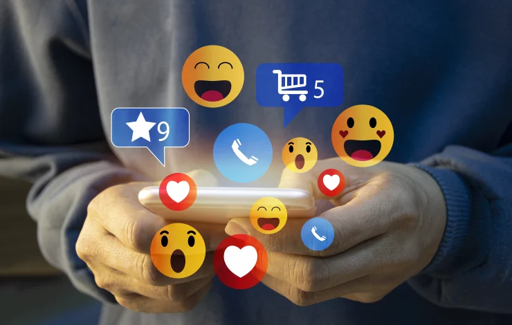 Person, die ein Smartphone verwendet, über dessen Bildschirm verschiedene Social-Media- und Benachrichtigungssymbole schweben, darunter Reaktionen, Einkaufswagen und Telefonsymbole.