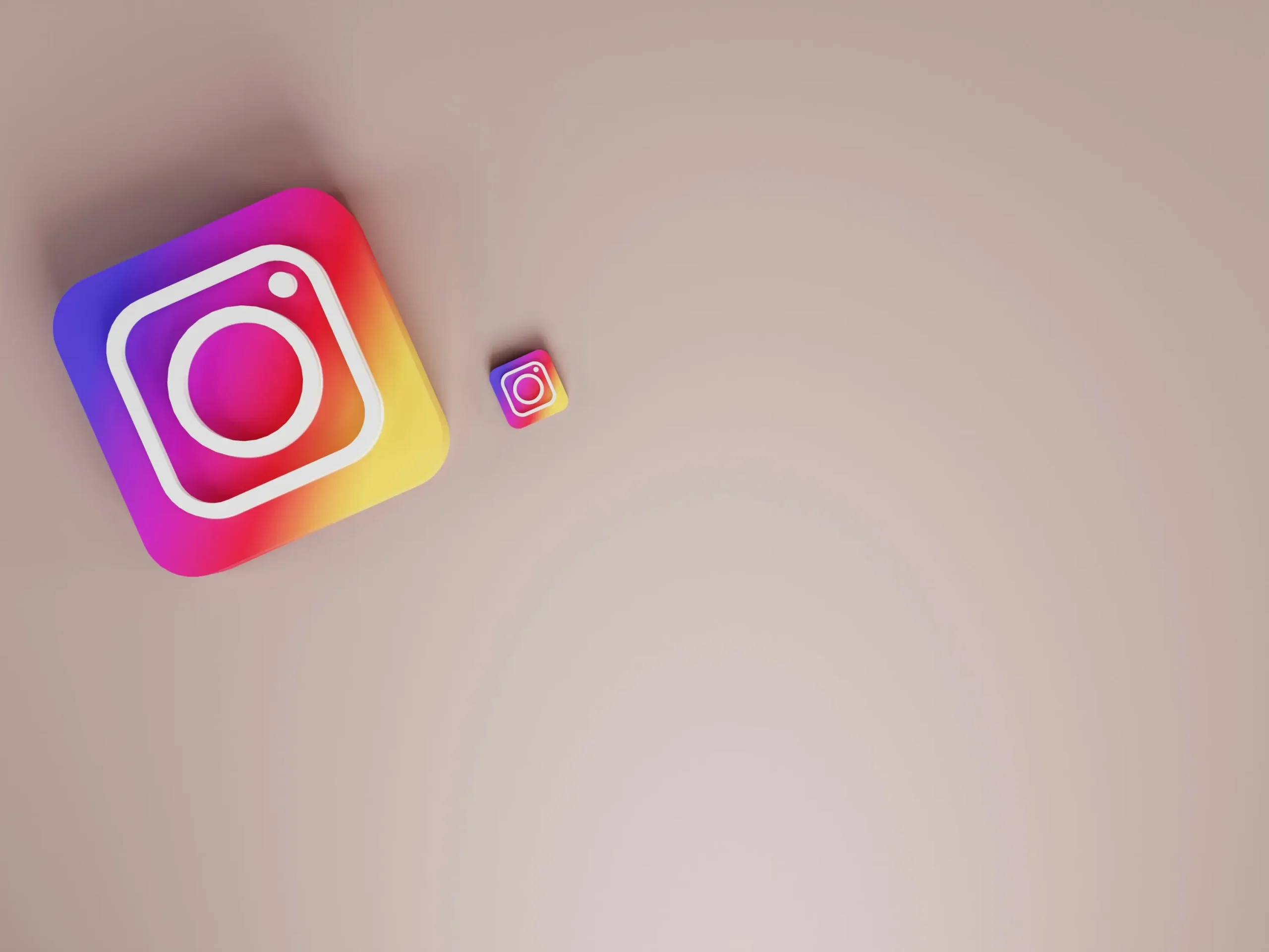 Zwei Instagram-App-Symbole, ein großes und ein kleines, auf beigem Hintergrund.