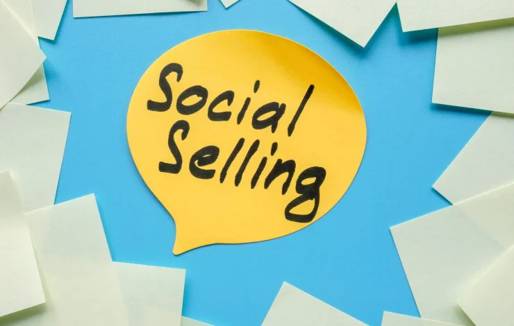 Gelbe Sprechblase mit dem Text „Social Selling“ auf blauem Hintergrund, umgeben von leeren Haftnotizen.