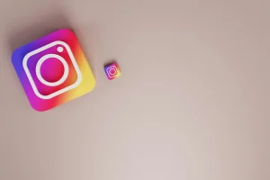Zwei Instagram-App-Symbole, ein großes und ein kleines, auf beigem Hintergrund.
